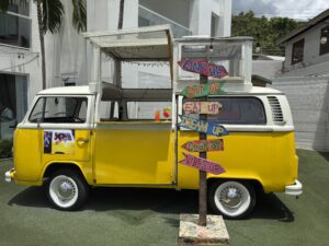Bob Marley Vintage yellow Volkswagen van converted into a tropical bar with colorful "Link Up," "Sit Up," "Eat Up," and "Vibes Up" signs outside a resort in Montego Bay, Jamaica.